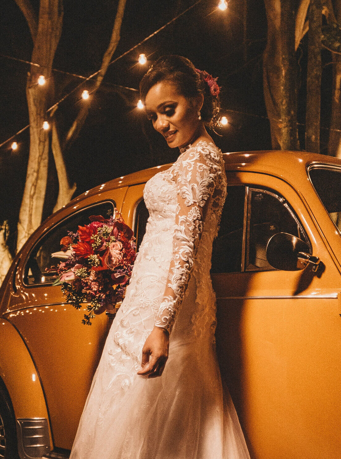 Photo of a woman in a wedding dress, standing next do a Volkswagen Bug