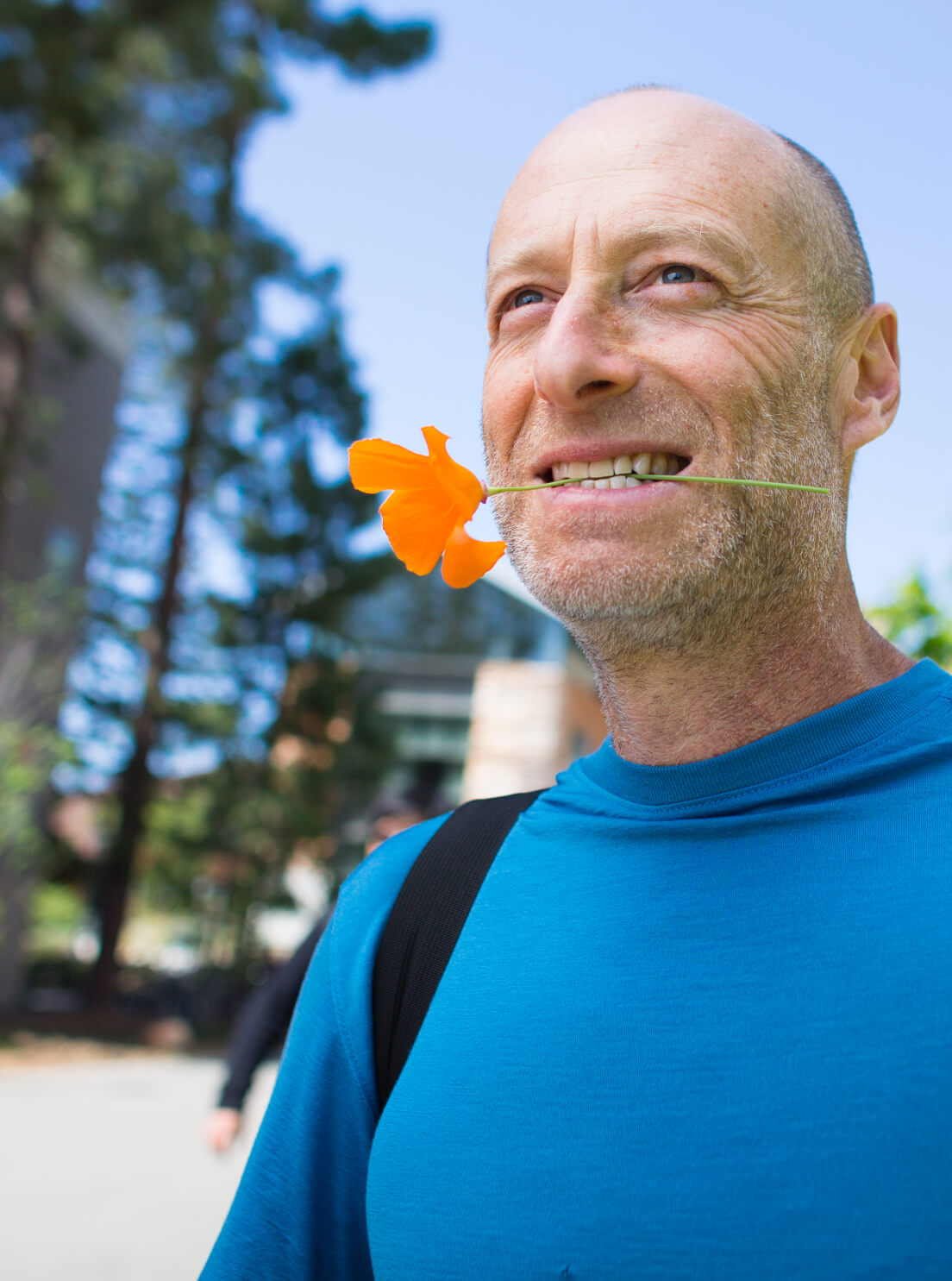 Photo of Statistics professor Philip Stark holding a flower with his mouth (Photo by Elena Zhukova. Copyright 2018 UC Regents.)