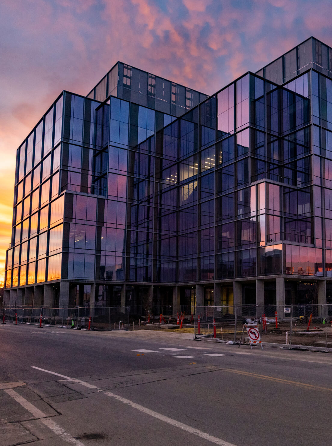 Building on a UC campus in front of a colorful sky.