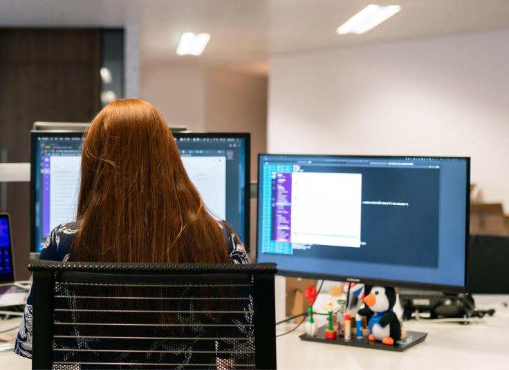 Female programmer with red hair sitting at a desk working