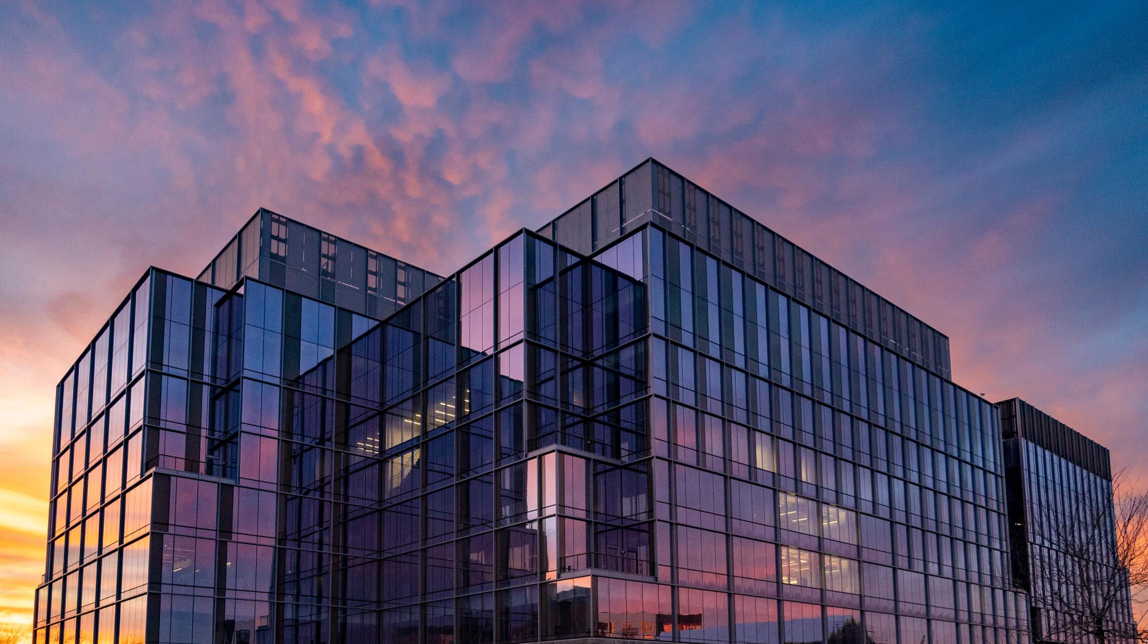 Building on a UC campus in front of a colorful sky.